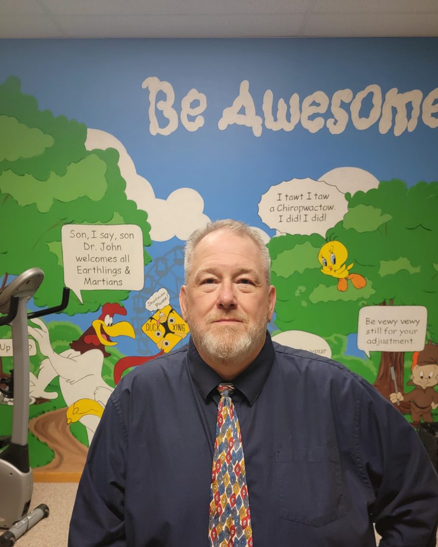 Dr. John Badinger in front of the Be Awesome mural at Family Health Chiropractic